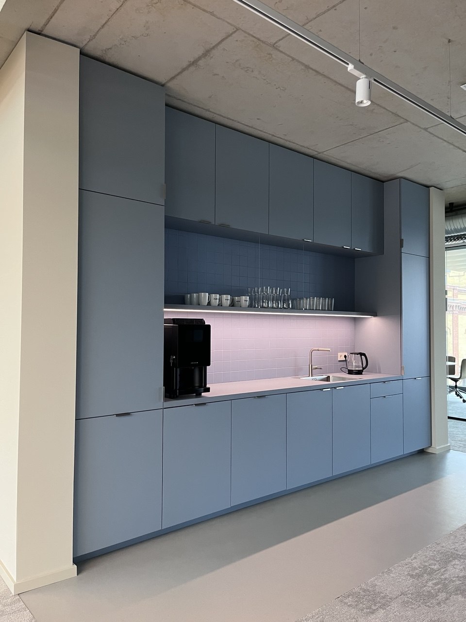 Küchenzeile in Blau vor Sichtbeton